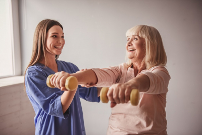 caregiver assisting senior woman doing exercise