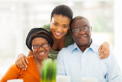 senior couple and their caregiver smiling