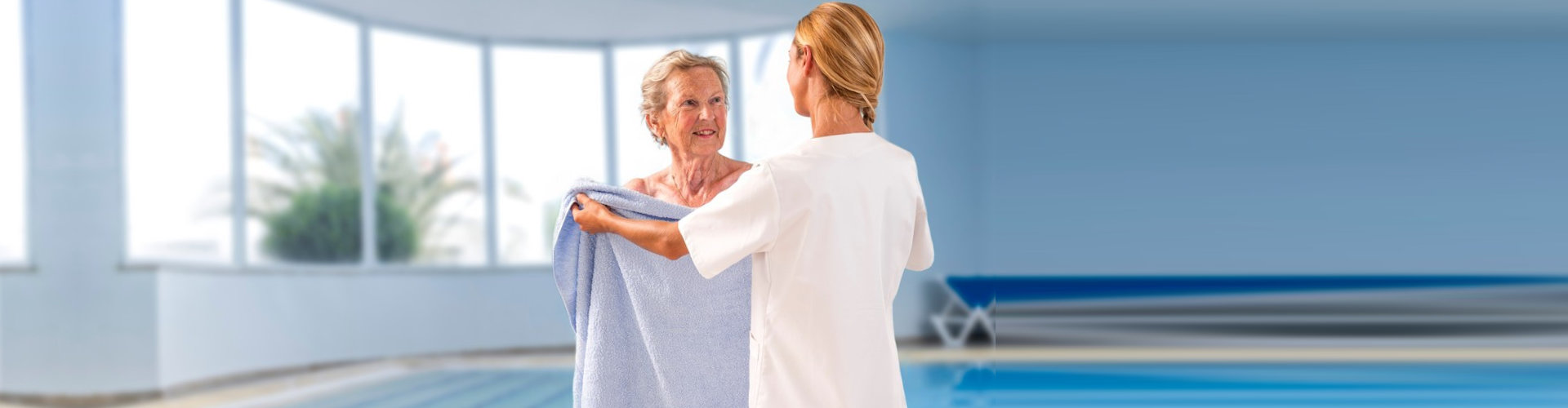 caregiver giving towel to a senior woman
