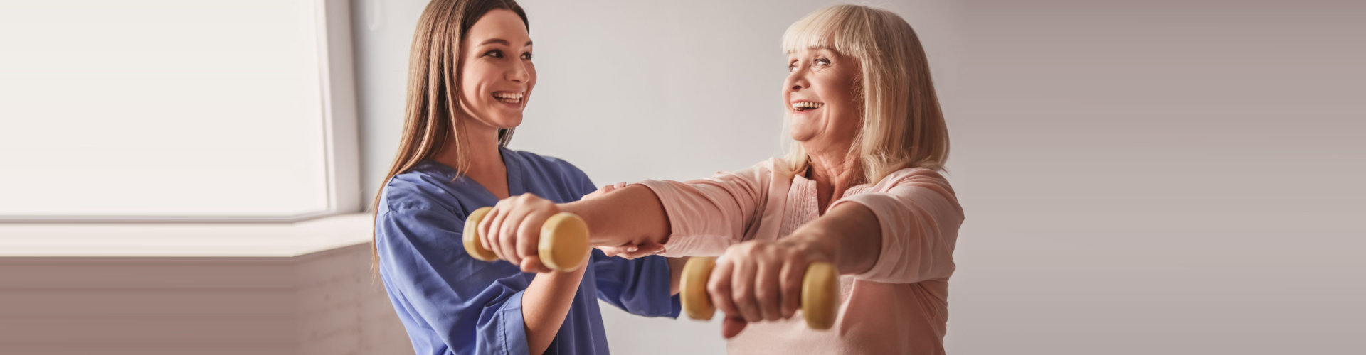 caregiver assisting senior woman doing exercise