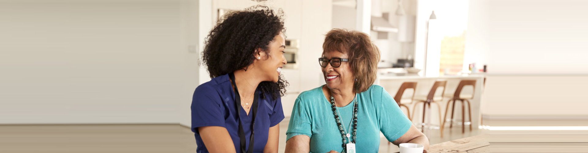 senior woman and caregiver smiling