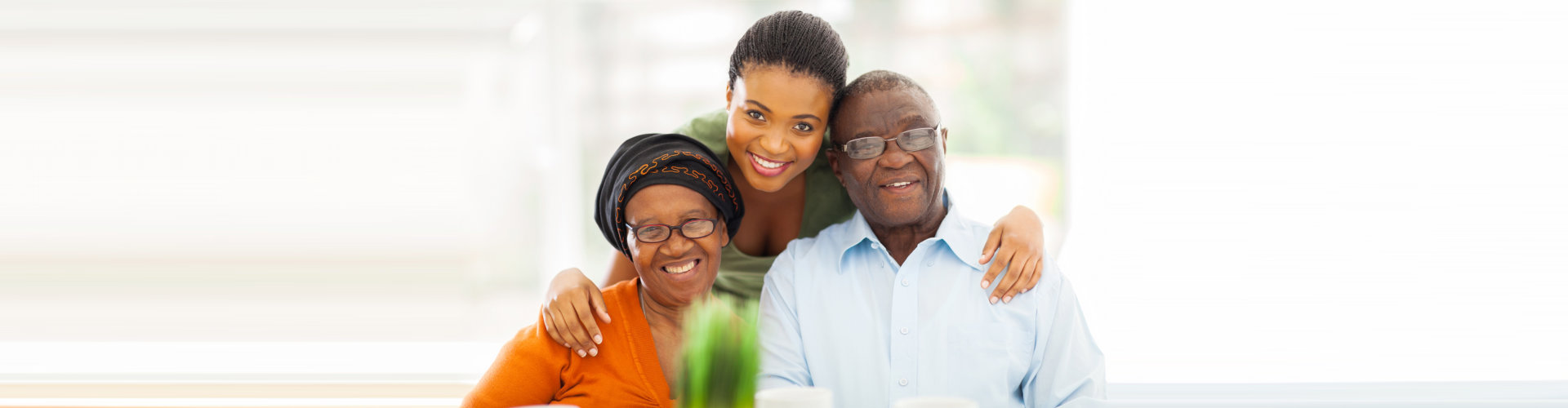 senior couple and their caregiver smiling