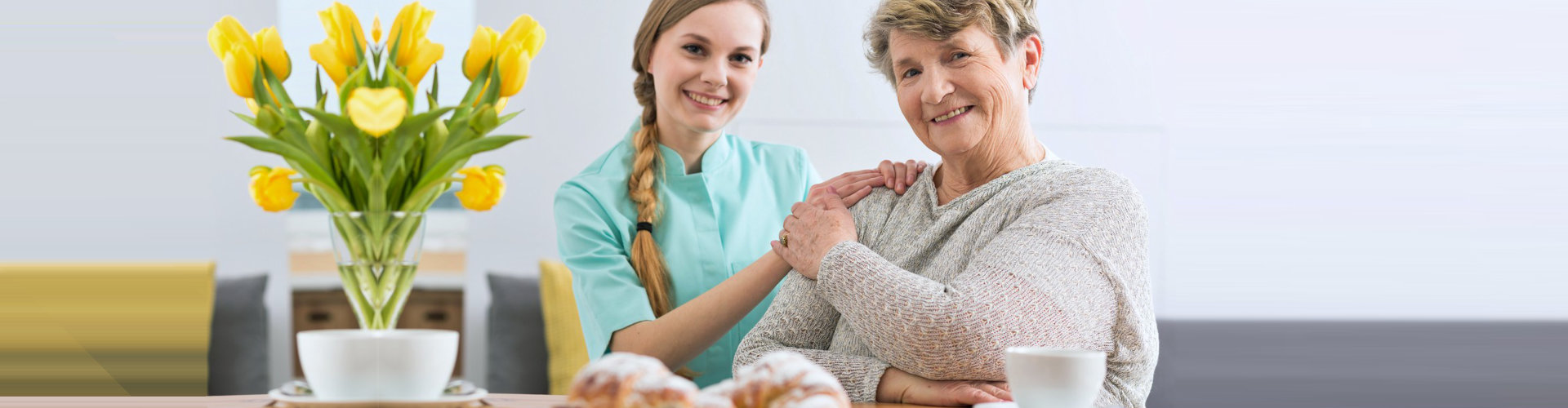 senior woman and caregiver smiling